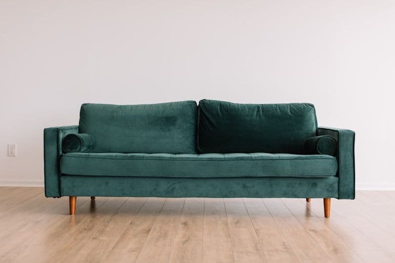 Minimalist living room corner with green velvet armchair